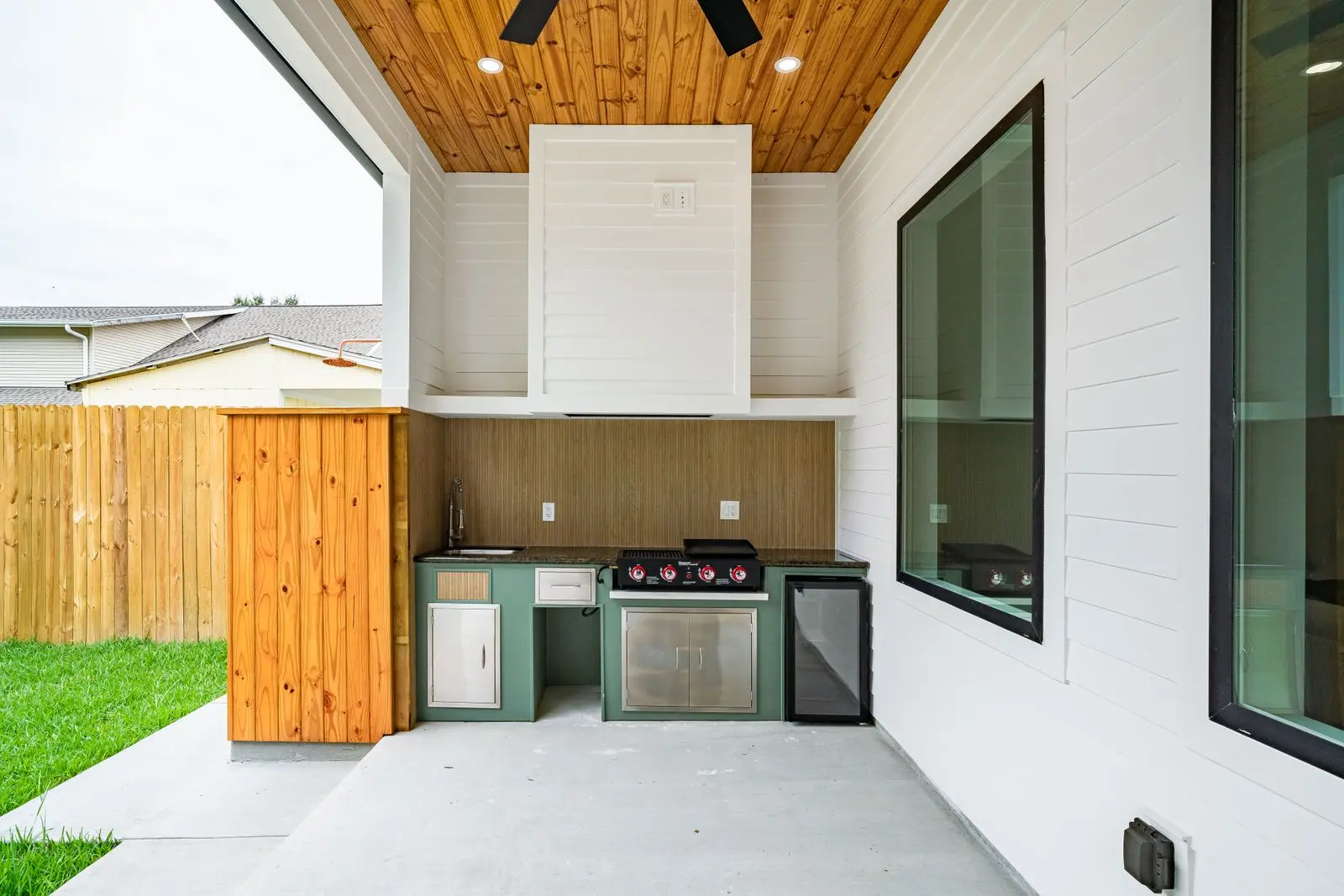 Modern backyard outdoor kitchen with a built in grill and counter